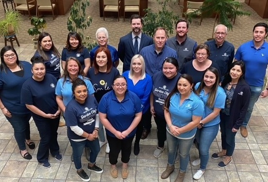 Garden City bank staff posing in blue shirts
